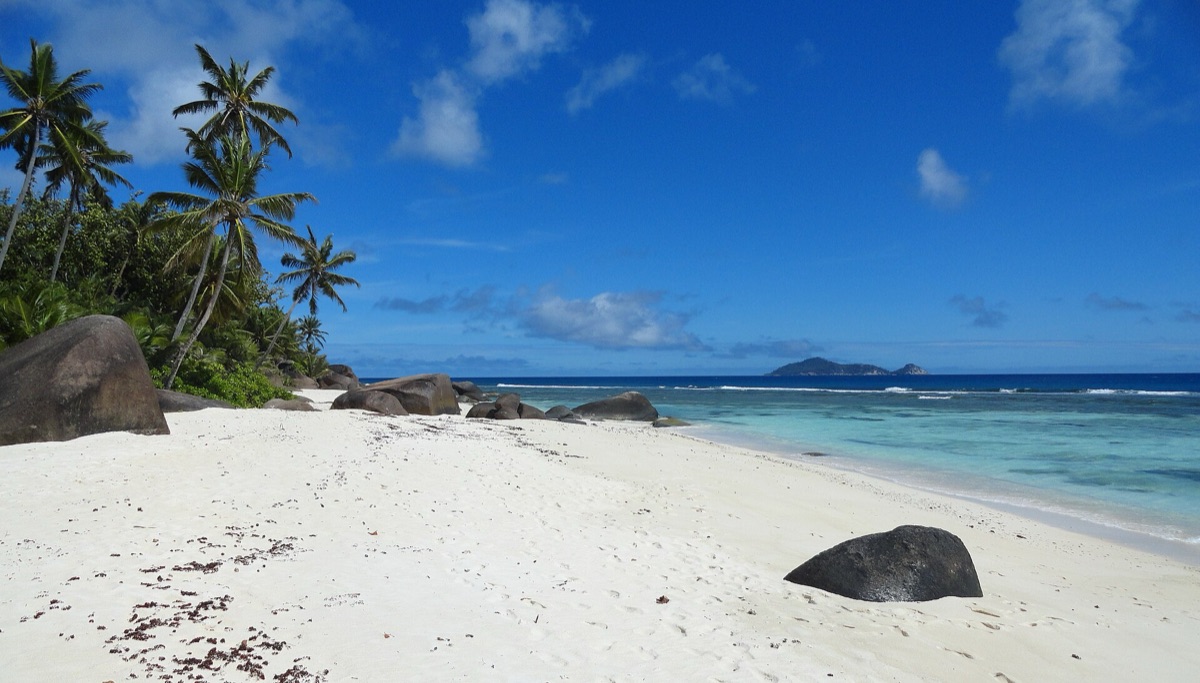 Een silhuette van een Seychelles eiland tegen de zonsondergang.