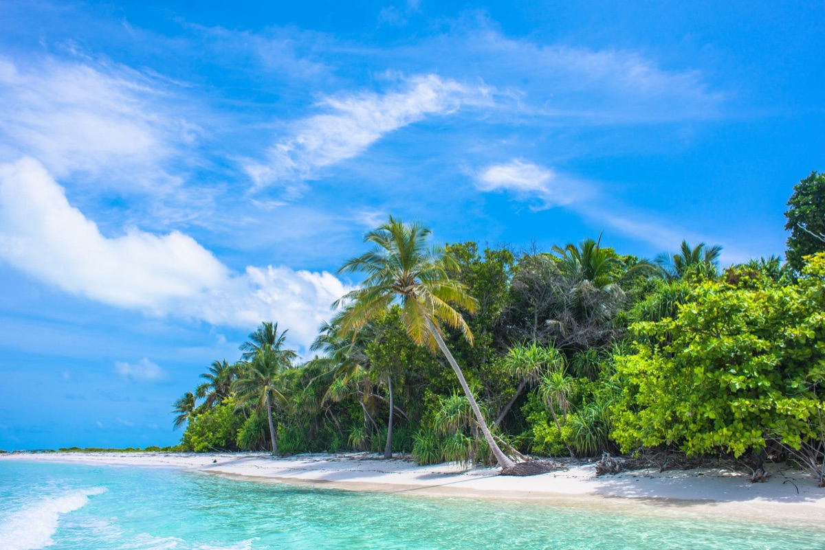 Ilha tropical com céu azul e sol pousando