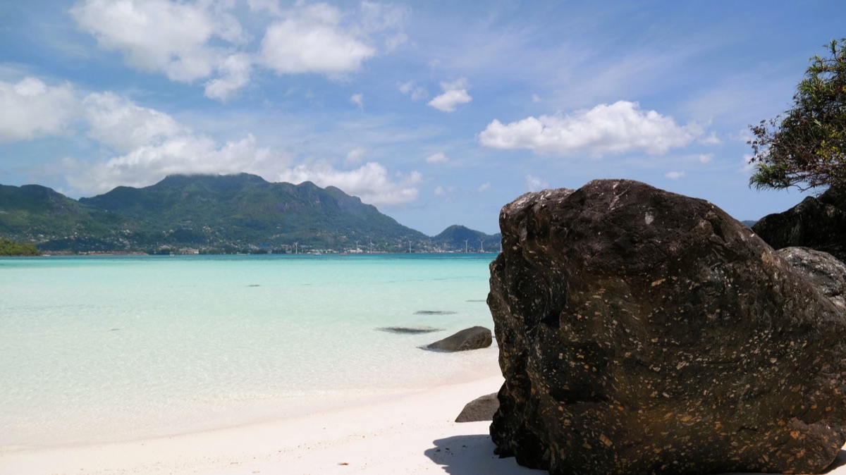 praia de seychelles com barcos coloridos