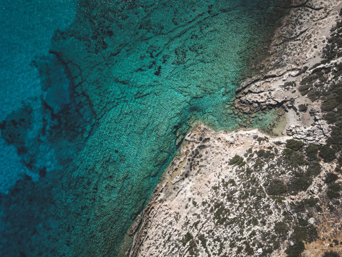 Geographical features of Radig Island, including cliffs, beaches, and dense forests